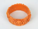 un bracelet orange orné d'une fleur