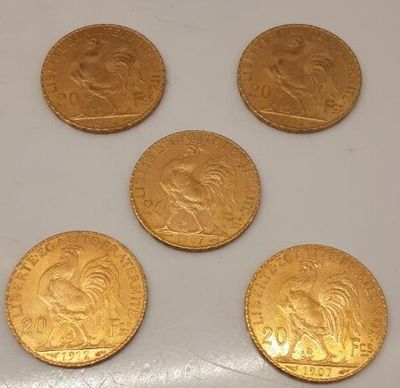 quatre pièces d'or sont posées sur une surface blanche