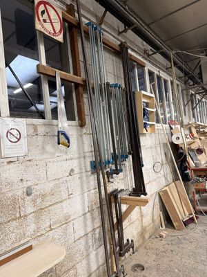 Plusieurs morceaux de bois sont empilés contre un mur dans un bâtiment
