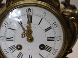 a gold clock with roman numerals on the face