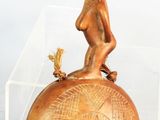 une petite statue représentant un garçon assis sur une balle