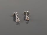 a pair of diamond earrings sitting on top of a table