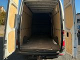 une camionnette blanche dont les portes sont ouvertes, garée sur un parking