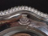 a silver plate with a crown on it on a table