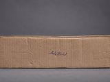 a cardboard box with writing on it sitting on a gray surface
