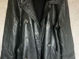 une veste en cuir noir suspendue à un cintre accroché au mur