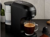une cafetière noire avec une tasse de café à côté
