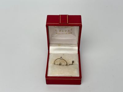 une petite bague dans une boîte rouge posée sur une surface blanche