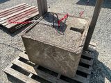 concrete block sitting on pallets in a parking lot next to a building