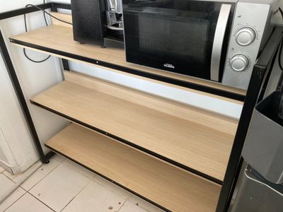 deux micro-ondes posés sur une étagère à côté d'un réfrigérateur