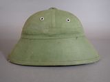 an image of a green hat with googly eyes on a gray surface