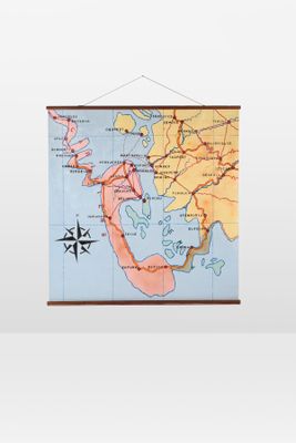 map of the world hanging on a wall with a compass on it