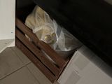une étagère noire sur laquelle sont posés plusieurs sacs de provisions