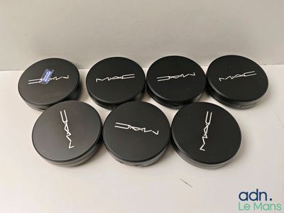 mac cosmetics products are displayed on a white surface