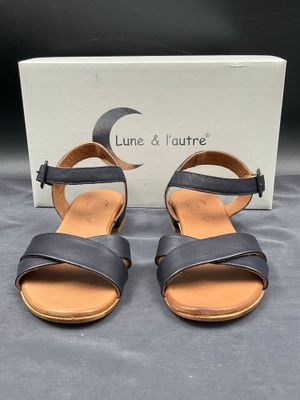 une paire de sandales en cuir noir à deux lanières et à bout ouvert