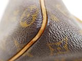 close up of a louis vuittoupe bag with a brown handle
