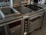 a kitchen with a stove, sink, and oven in it