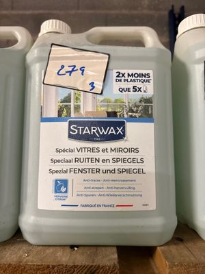 trois gallons de Starwax sont posés sur une table en bois