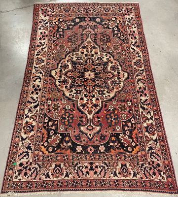 an antique persian rug with a large medallion design