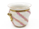 a white vase with pink and gold stripes on it