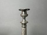 pair of antique silver candlesticks on a grey background