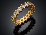 a yellow gold ring with diamonds on a black background