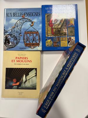 Plusieurs livres sont posés sur une table, à côté d'une tasse de café