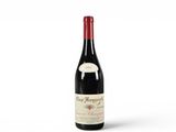 une bouteille de vin rouge posée sur une table blanche