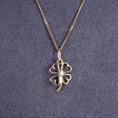 un gros plan sur un collier en or orné d'une fleur