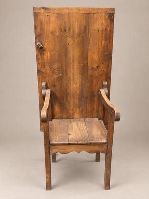 une vieille chaise en bois posée sur un parquet