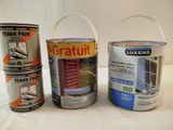 trois pots de peinture posés les uns à côté des autres sur une table