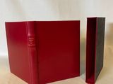deux livres rouges posés l'un à côté de l'autre sur une surface blanche