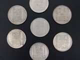 six silver coins are arranged in a circle on a black surface
