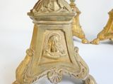 a gold clock on a white table with a white background