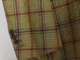 the back of a man ' s jacket with a red and green checkered pattern