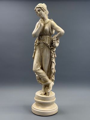 une image représentant une statue d'une femme tenant une fleur à la main