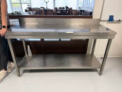 une femme debout devant une table en acier inoxydable