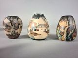 three vases with different designs on them sitting on a table