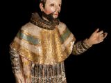 statue of a man with a beard wearing a gold and green outfit