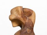 wooden sculpture of a woman ' s head on a white pedestal
