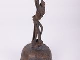 statue représentant un homme tenant un oiseau sur une cloche