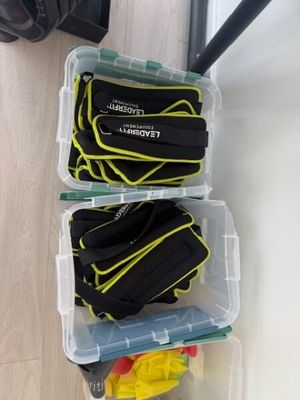 two plastic containers filled with black and yellow items sitting on top of a wooden floor