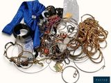 une pile de bijoux assortis sur une surface blanche