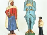 several figurines of men and women are displayed on a white surface