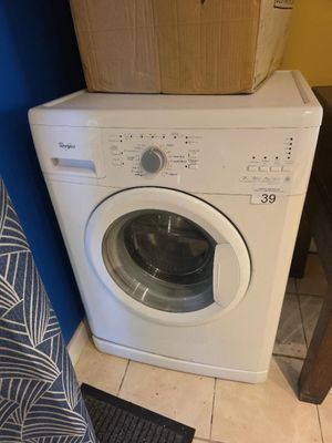 une machine à laver posée sur une pile de cartons