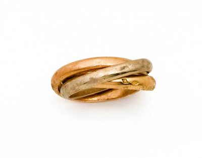 une bague en or posée sur une surface blanche, surmontée d'une autre bague en or