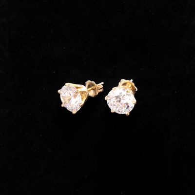 a pair of diamond earrings on a black background