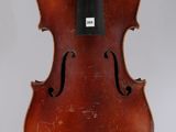 an old violin sitting on top of a white surface