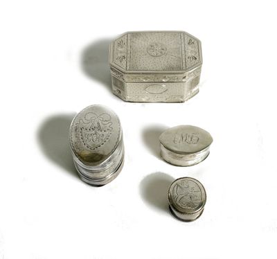 une petite boîte en argent et deux pièces de monnaie posées sur une surface blanche