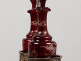 a red vase sitting on top of a wooden table